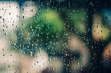 Rain water drop on window with Green nature bokeh for background.soft focus background concept.