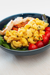 close-up of plate of pasta and chicken with lettuce