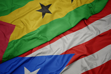 waving colorful flag of puerto rico and national flag of sao tome and principe .