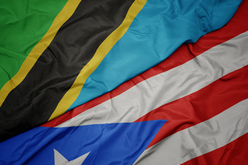 waving colorful flag of puerto rico and national flag of tanzania.