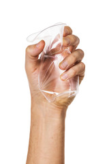 Crumpled plastic cup in hand isolated on a white background. Hand squeezes a disposable glass