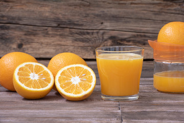 Un vaso de jugo de naranja y el exprimidor.