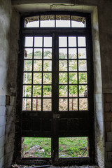 Fototapeta na wymiar ventana de fábrica abandonada con cristales rotos