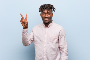 Young business african black man joyful and carefree showing a peace symbol with fingers.