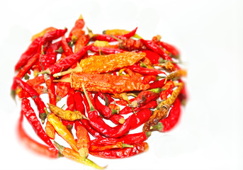 dried hot chili peppers, yellow and green pods on a light background