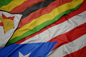 waving colorful flag of puerto rico and national flag of zimbabwe.