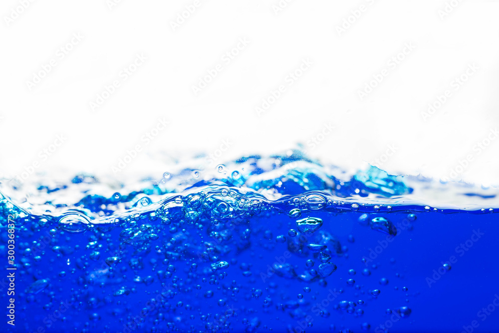 Wall mural close up blue water splash with bubbles on white background