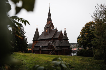 Old wooden Gustav Adolf Stave Church in Hahnenklee in the Harz region as spotted during a rainy autumn day with falling leaves and lush greens (Germany, Europe)