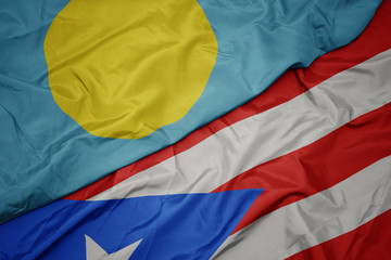waving colorful flag of puerto rico and national flag of Palau .
