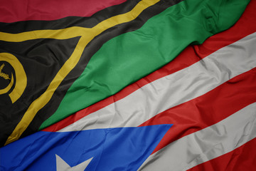 waving colorful flag of puerto rico and national flag of Vanuatu .