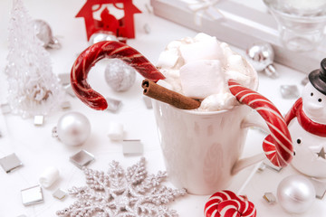 hot chocolate, cocoa with marshmallows and lollipops, silver balls, candle, snowflake, transparent Christmas tree, Christmas decor, cinnamon, snowman, snow, top view