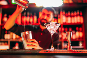 Silhouette of classic bartender shaking drink at fashion cocktail bar