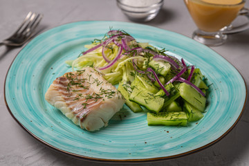 Boiled cod salad with cucumber, cabbage and red onion. Dish for people with diabetes and overweight