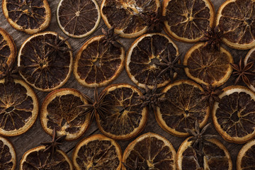Fototapeta na wymiar top view of dried orange slices on wooden background with anise