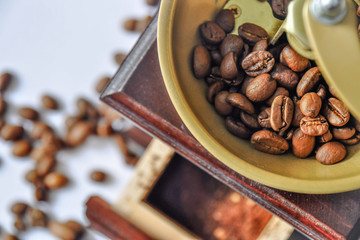 Details of coffee beans and a wooden grinder/mill. Vintage coffee mill isolated on white background. Manual coffee grinder. 