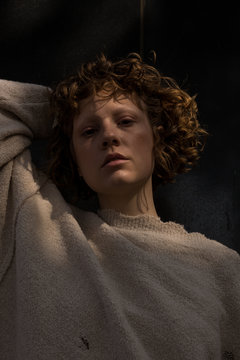 Close up of woman with curly hair in white sweater