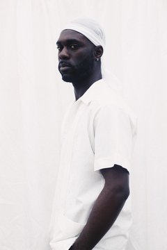 Profile Of Man In White Clothes In Front Of White Wall