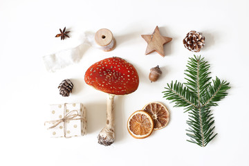 Christmas natural styled stock composition. Red fly agaric mushroom, gift box, pine cones, fir tree...