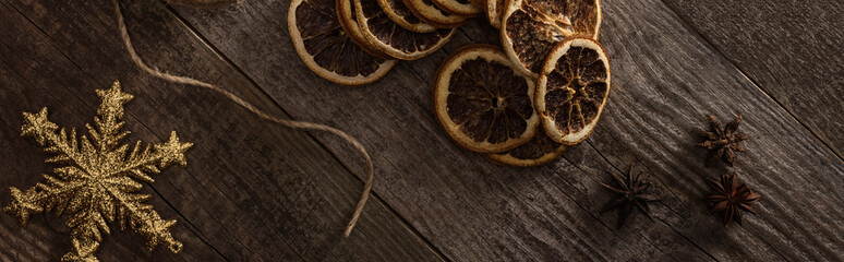 top view of thread,snowflake and dried citrus slices on wooden background, panoramic shot