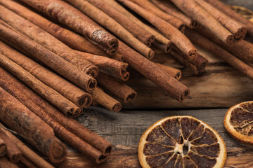 cinnamon sticks near dried citrus slices on wooden background