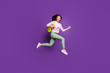 Full length body size profile side view of nice attractive slim fit slender thin cheerful girl jumping running highschool isolated on bright vivid shine vibrant purple violet lilac color background