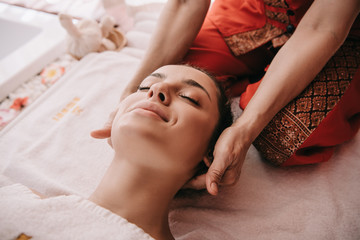 Fototapeta na wymiar cropped view of masseur doing neck massage to woman in spa salon