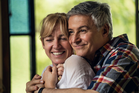Mature couple embracing at home