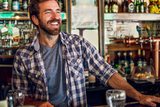 Smiling man standing at beer counter in the bar