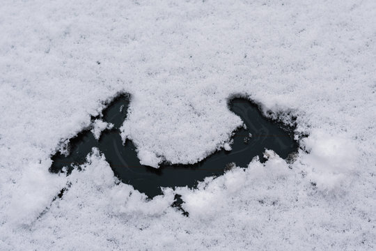 Snow happy face on the car window. Winter concept