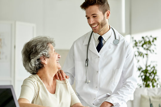 Smiling doctor consoling senior woman in clinic