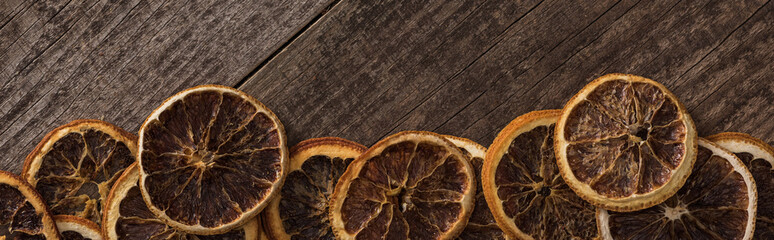 panoramic shot of dried orange slices on wooden background