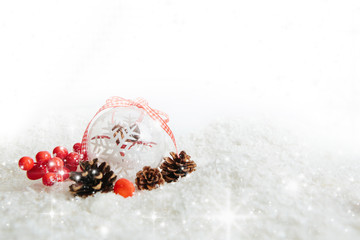 Obraz na płótnie Canvas Transparent Christmas ball hanging on red ribbon on snowy winter background Beautiful Christmas bauble decorations lie on the white fluffy snow. Atmosphere of magic and fairy tales