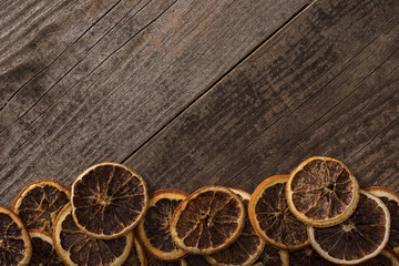 top view of dried orange slices on wooden background with copy space