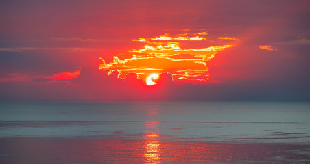 Panele Szklane  Niesamowity wschód słońca nad morzem przez chmury