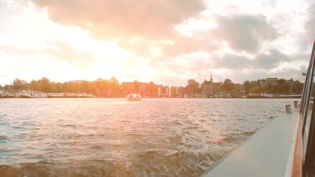 Amsterdam, Netherlands - September 2019: Sunset over the Amstel River and Lake Ij. View from a tourist cruise boat