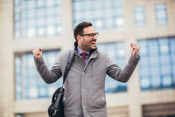 Businessman raising his arms outdoors - happy, success and achievement concepts