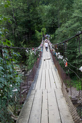 Ecotourism concept. Suspension bridge over a mountain river