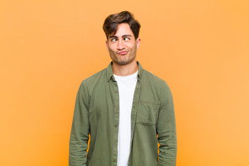 young handsome man looking goofy and funny with a silly cross-eyed expression, joking and fooling...
