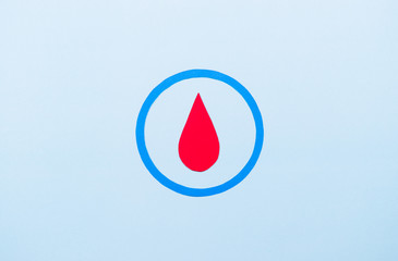 Symbol of diabetes with blood drop on pastel blue background. World diabetes day concept.