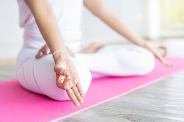 Woman doing yoga exercise in the indoor gym close up with copy space background.  Concept of good health and wellness.