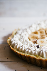 Lemon tart with french meringue caramelized on top, on a rustic table, french meringue caramelized with a food torch.