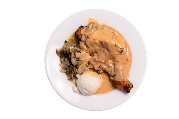 Roasted chicken with potato and vegetables dripped with gravy sauce close up. Isolated in white background.