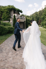 Happy just married couple walking outside in wedding day