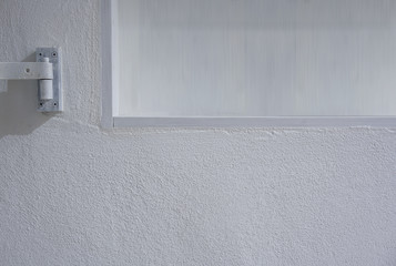 Empty shelf in white wall with small part of shutter