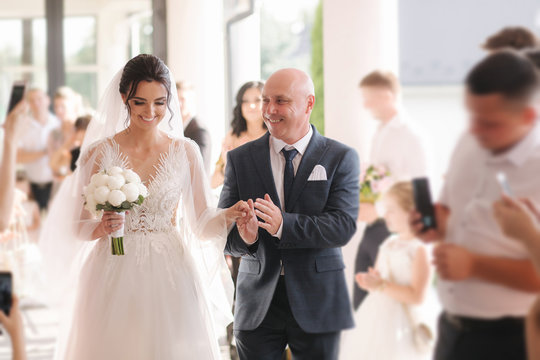 Happy father leading his daughter to the altar. Dad is proud of his beautiful daughter. Wedding ceremony