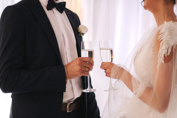 Middle selection of newlyweds hold a glasses of champagne