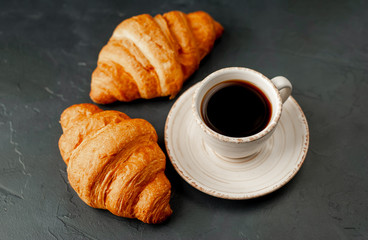coffee and croissants on a stone background, morning breakfast