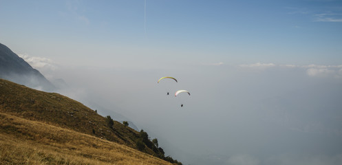 Paraglider flying over the Garda Lake,Panorama of the gorgeous Garda lake surrounded by mountains, Malcesine, Italy 