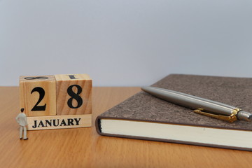 January  28, a calendar photo from the wood The table top consists of a book and pen that is ready to use. White background