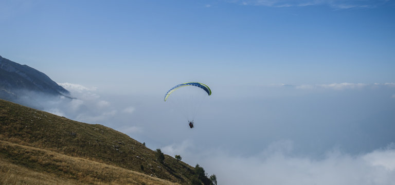 Paraglider flying over the Garda Lake,Panorama of the gorgeous Garda lake surrounded by mountains, Malcesine, Italy 